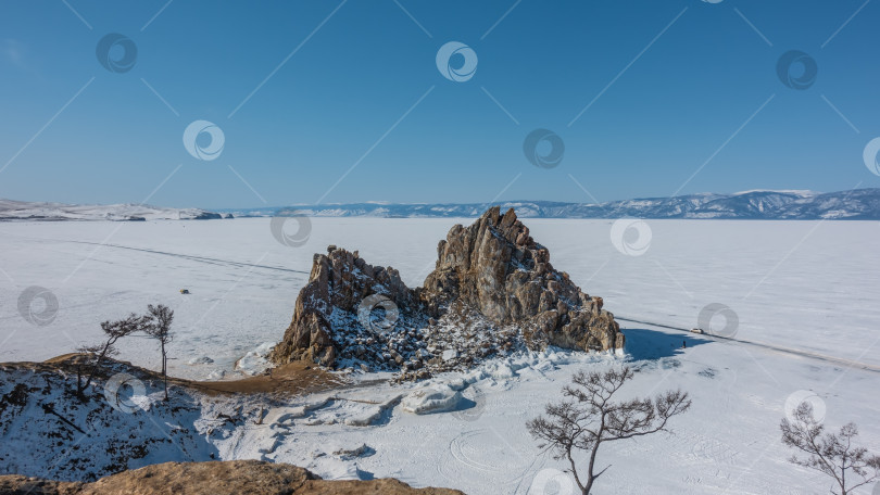 Скачать Живописная двуглавая скала на фоне замерзшего озера. фотосток Ozero