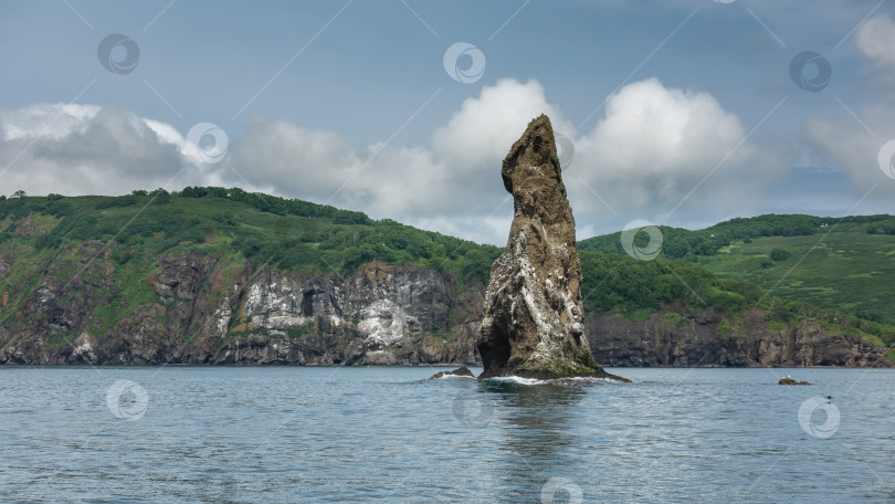 Скачать Над водой возвышается высокий живописный утес. фотосток Ozero