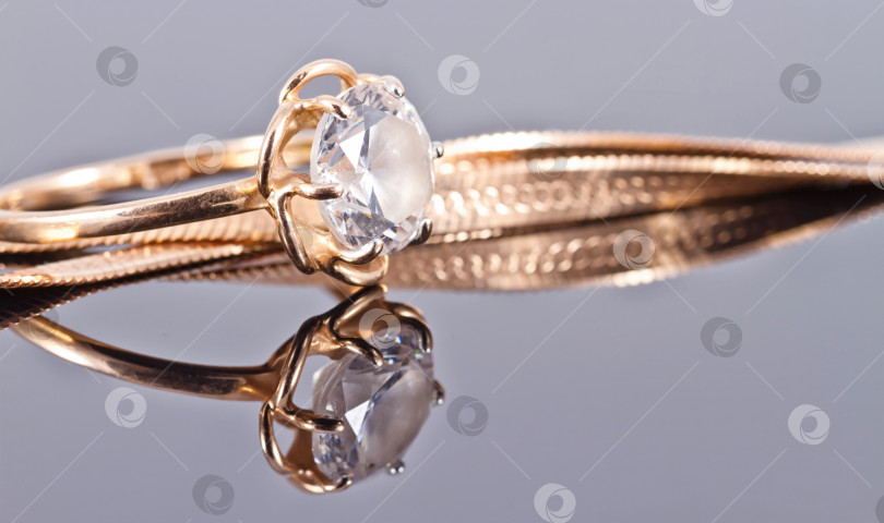 Скачать Тонкое нежное золотое кольцо с бриллиантом и золотой цепочкой фотосток Ozero