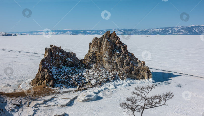 Скачать Живописная двуглавая скала возвышается на замерзшем озере. фотосток Ozero
