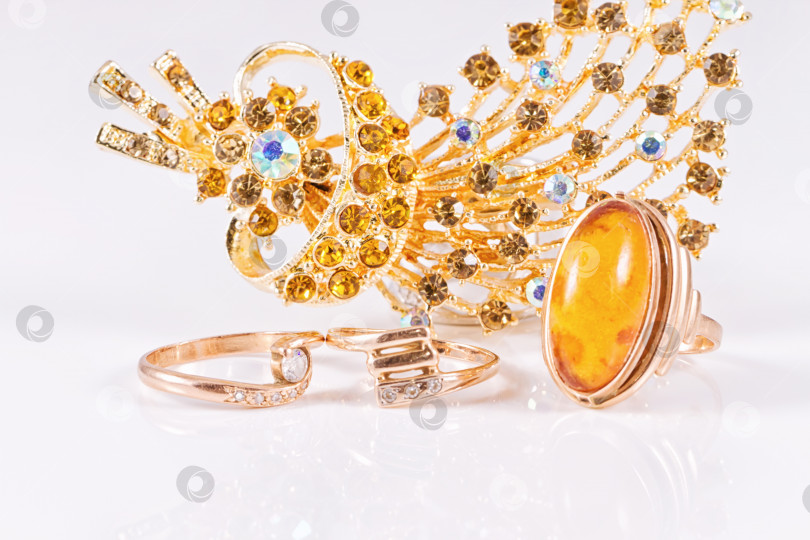Скачать Большое золотое кольцо с янтарем и золотой брошью фотосток Ozero
