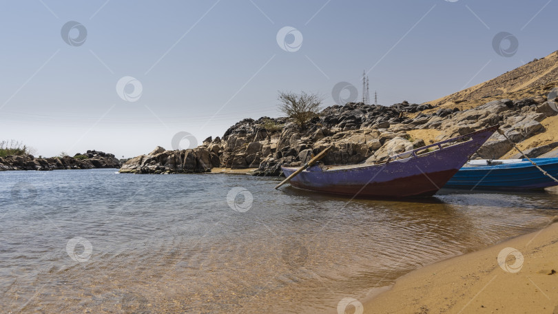 Скачать Старые раскрашенные деревянные лодки пришвартованы к песчаному берегу Нила. фотосток Ozero