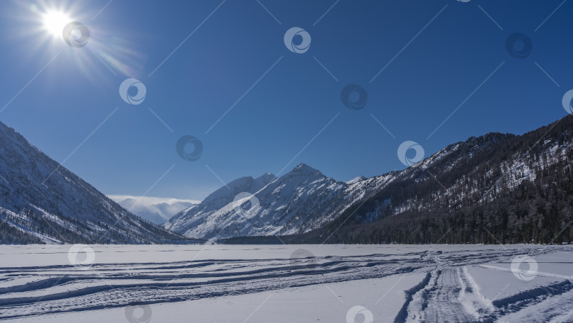 Скачать Замерзшее озеро окружено живописными горами. фотосток Ozero