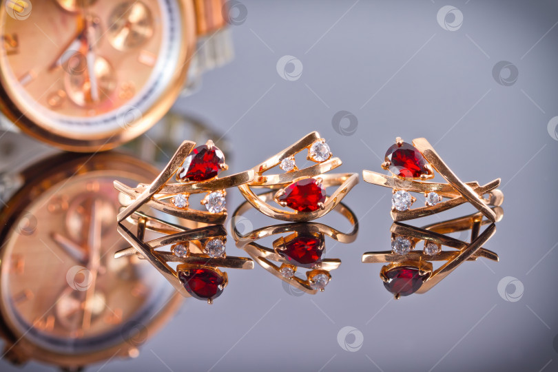 Скачать Золотые серьги и кольца с красными рубинами и часы фотосток Ozero