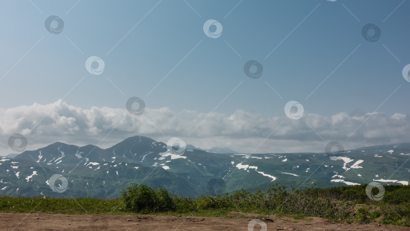 Скачать Живописный горный хребет на фоне голубого неба с облаками. фотосток Ozero