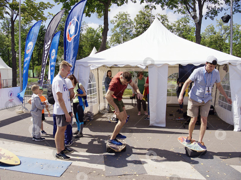 Скачать Молдые люди учатся стоять и кататься на скейборде. Спортивный праздник в Лужниках. фотосток Ozero