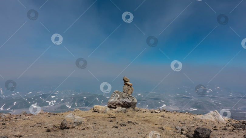 Скачать На вершине горы сложена пирамида из вулканических камней. фотосток Ozero