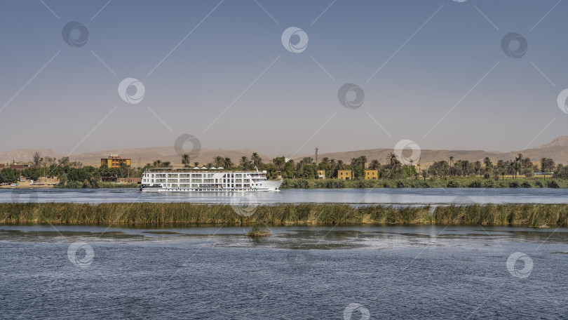 Скачать Белый туристический корабль плывет вдоль берега Нила. фотосток Ozero