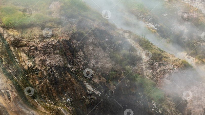 Скачать Склон холма окутан густым паром от извергающегося гейзера. фотосток Ozero