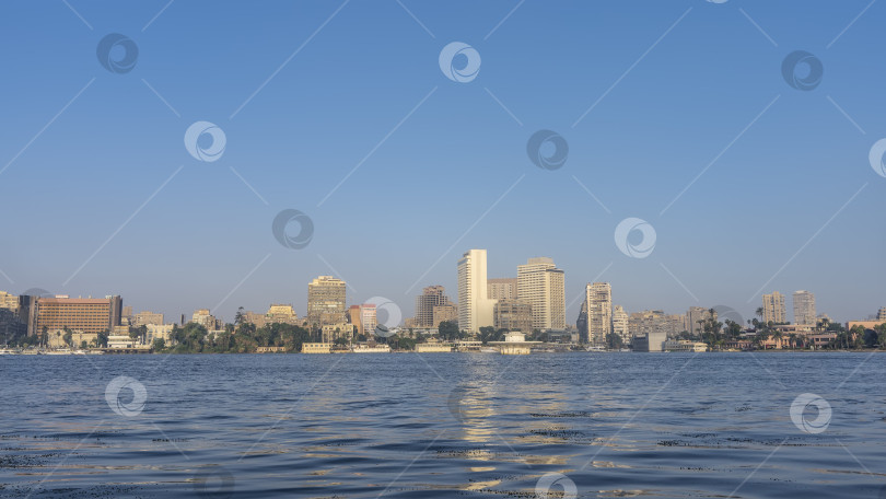 Скачать На берегах Нила в Каире видны городские дома и зеленая растительность. фотосток Ozero