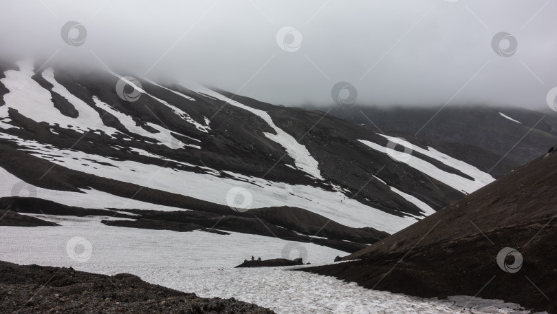 Скачать На скалистых склонах гор происходит таяние снега. фотосток Ozero