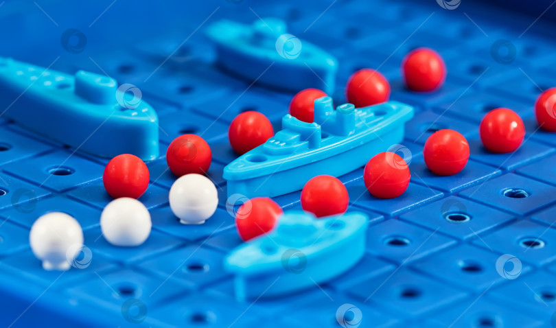 Скачать Игрушечные военные корабли и подводная лодка размещены на синей игровой доске фотосток Ozero