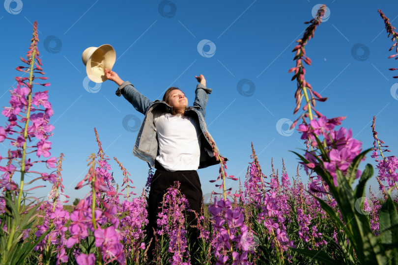Скачать улыбающаяся молодая женщина в шляпе на цветочном поле. счастье, природа, лето, концепция отпуска фотосток Ozero