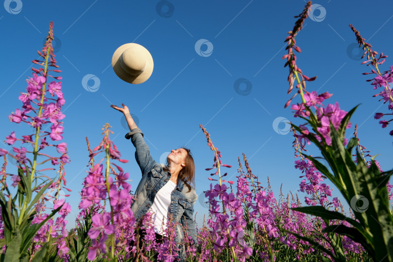 Скачать улыбающаяся молодая женщина в шляпе на цветочном поле. счастье, природа, лето, концепция отпуска фотосток Ozero