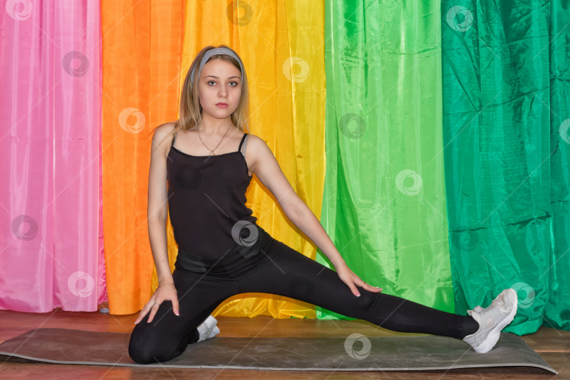 Скачать молодая женщина в спортивной одежде выполняет упражнения на гимнастическом коврике фотосток Ozero