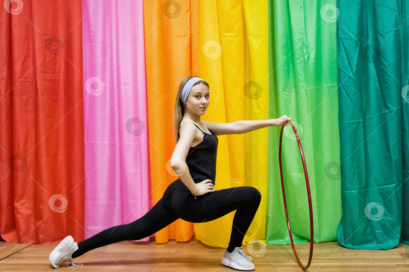 Скачать Гибкая молодая женщина в спортивной одежде делает упражнения с обручем фотосток Ozero