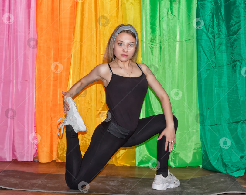 Скачать молодая женщина в спортивной одежде выполняет упражнения на гимнастическом коврике фотосток Ozero