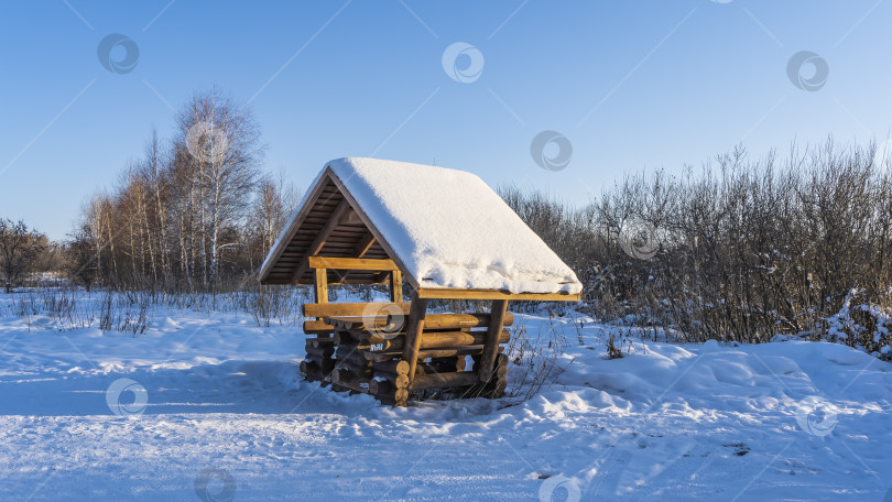 Скачать Некрашеная бревенчатая беседка стоит в сугробах. фотосток Ozero