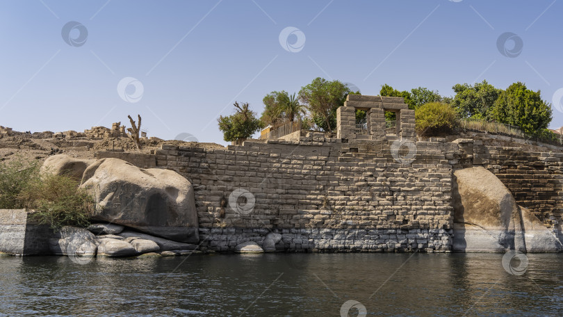 Скачать Выветрившаяся кирпичная стена укрепляет берега реки. фотосток Ozero