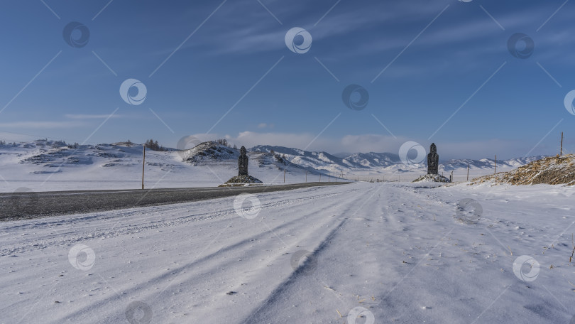 Скачать Асфальтированная дорога проходит через заснеженную долину. фотосток Ozero