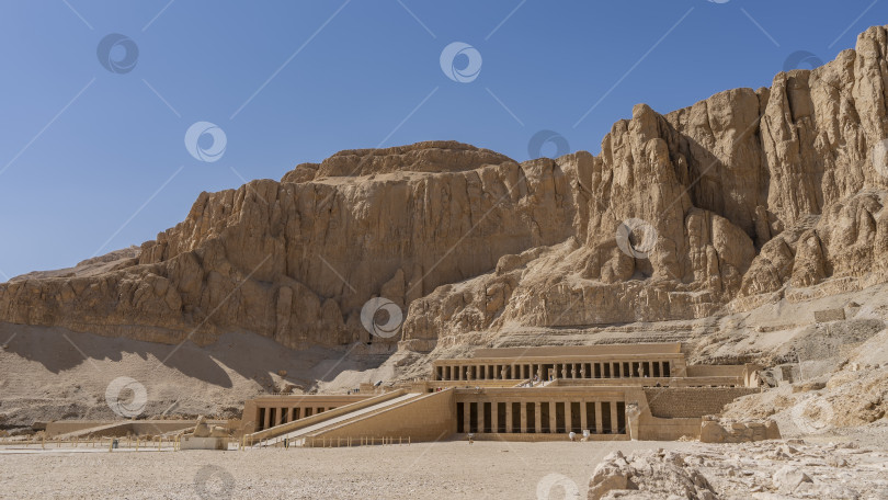 Скачать Заупокойный храм царицы фараона Хатшепсут на фоне живописных отвесных скал. = фотосток Ozero