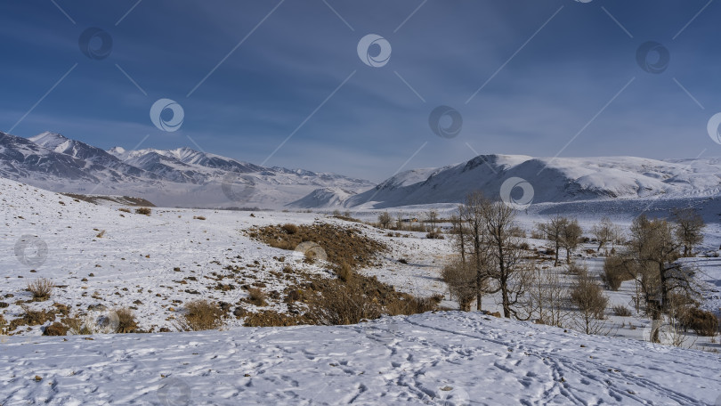 Скачать Заснеженная долина окружена горным хребтом. фотосток Ozero