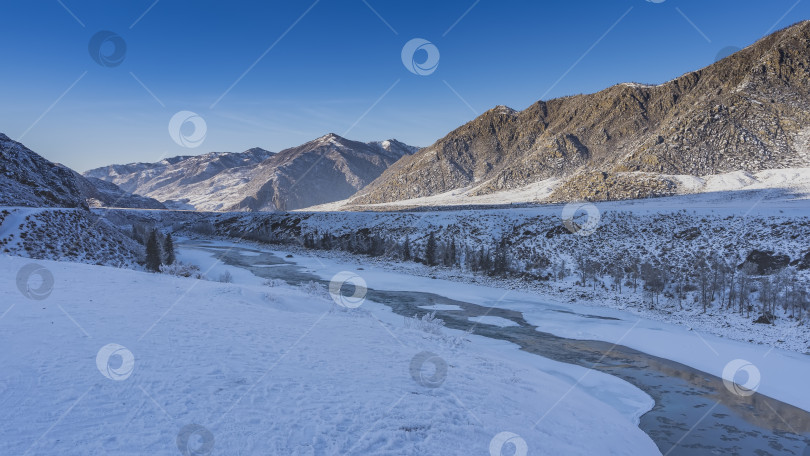 Скачать Бирюзовая река течет между замерзшими берегами. фотосток Ozero