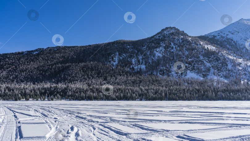 Скачать На замерзшем и заснеженном озере видны следы шин. фотосток Ozero