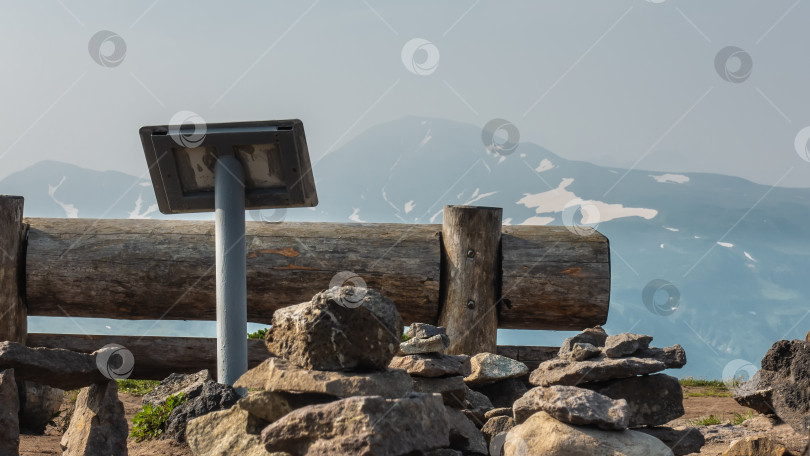 Скачать На краю плато стоит скамейка, сделанная из некрашеных бревен. фотосток Ozero