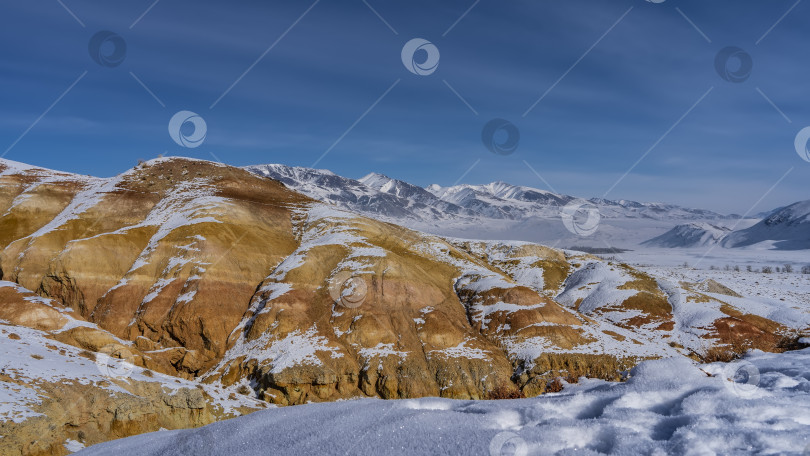 Скачать Яркие красно-оранжевые холмы в заснеженной долине. фотосток Ozero