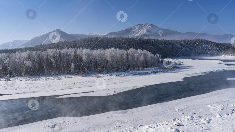 Скачать Незамерзающая река течет по заснеженной долине. фотосток Ozero