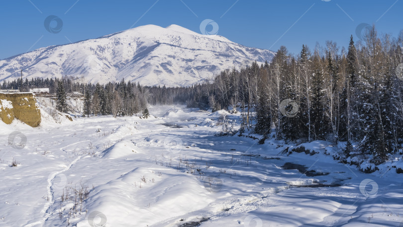 Скачать Русло замерзшей реки покрыто сугробами снега. фотосток Ozero