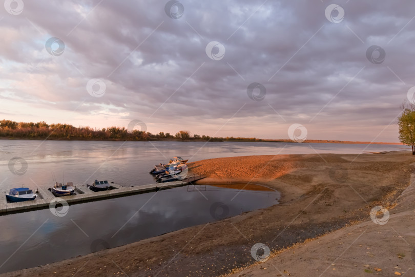 Скачать Пирс с моторными лодками от песчаного пляжа на закате фотосток Ozero