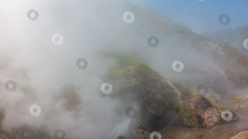 Скачать Склон холма окутан густым паром от извергающегося гейзера. фотосток Ozero