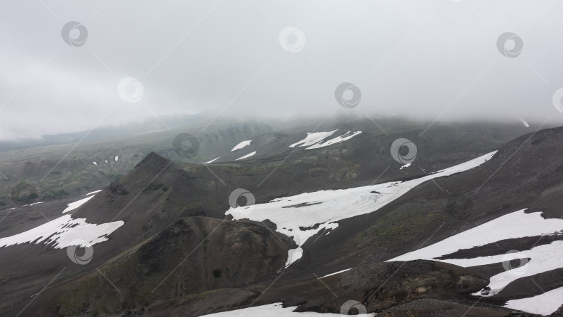 Скачать Горные вершины окутаны туманом и скрыты низкими облаками. фотосток Ozero