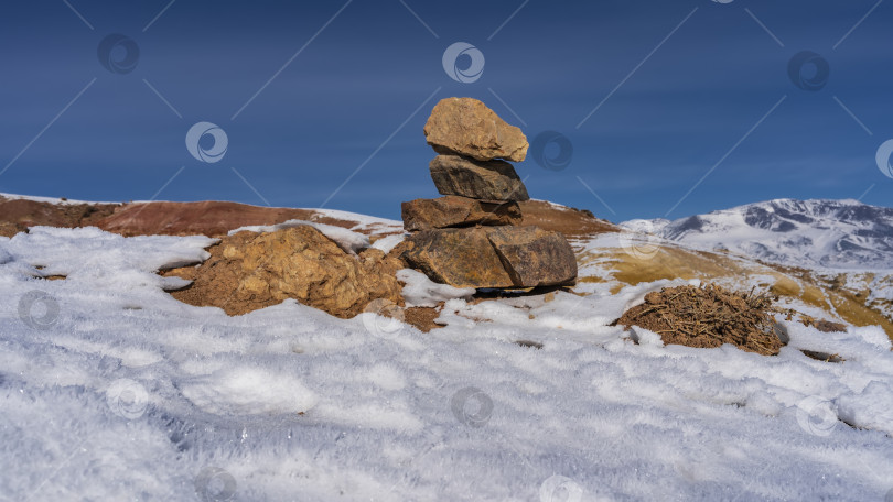 Скачать На склоне холма сложена пирамида из красно-коричневых камней. фотосток Ozero