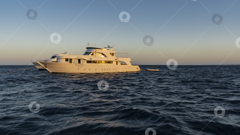 Скачать Белые яхты в синем море освещены лучами вечернего солнца. фотосток Ozero