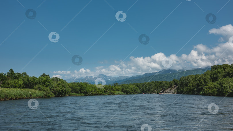 Скачать Спокойная голубая река течет под лазурным небом. фотосток Ozero