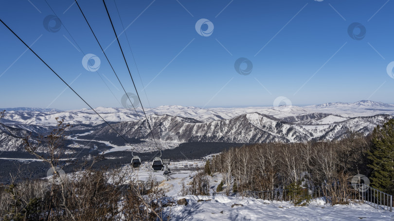 Скачать Фуникулер проходит над заснеженной долиной. фотосток Ozero