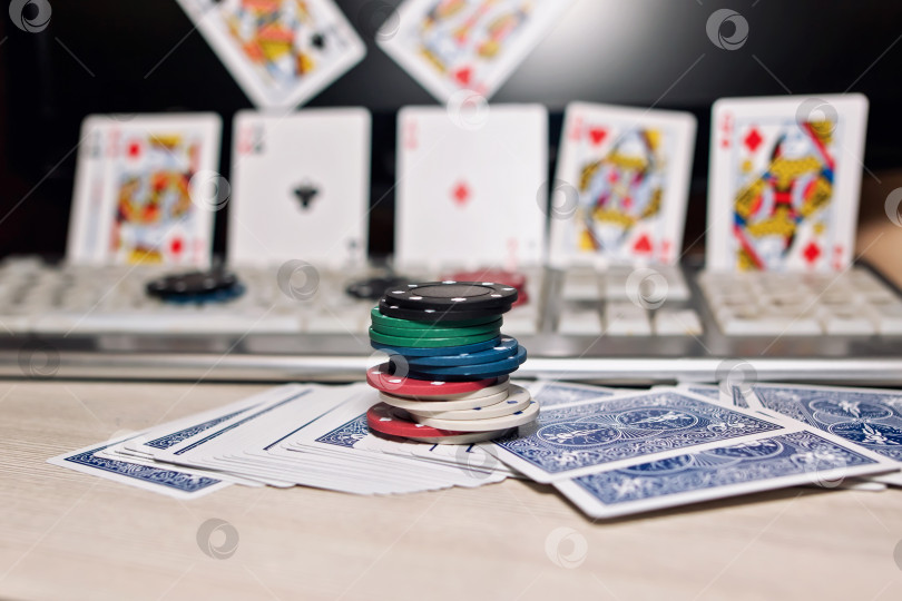 Скачать Рабочий стол игрока в онлайн-казино с разбросанными картами и покерными фишками фотосток Ozero