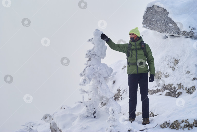 Скачать турист с портативной рацией всматривается вдаль, стоя на фотосток Ozero