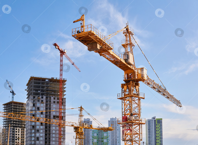 Скачать строительные башенные краны на строительной площадке на фоне неба фотосток Ozero