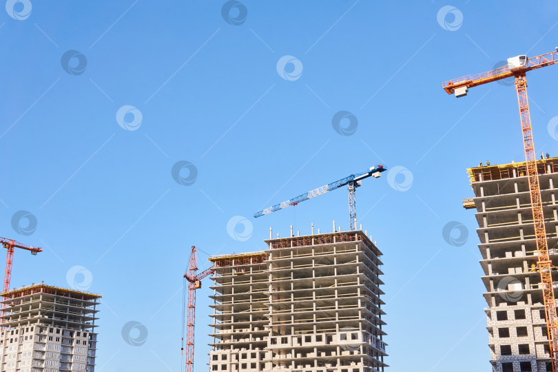 Скачать строительные башенные краны на строительной площадке на фоне неба фотосток Ozero
