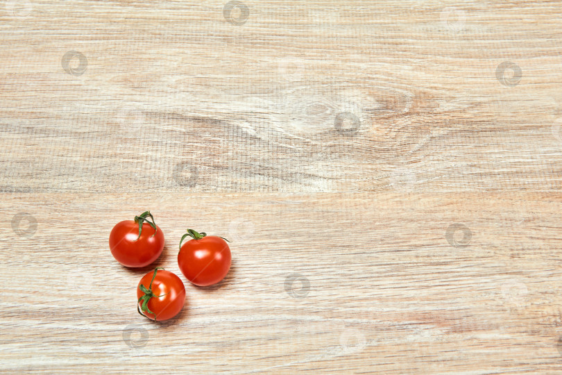 Скачать три маленьких помидора черри на деревянной поверхности стола фотосток Ozero