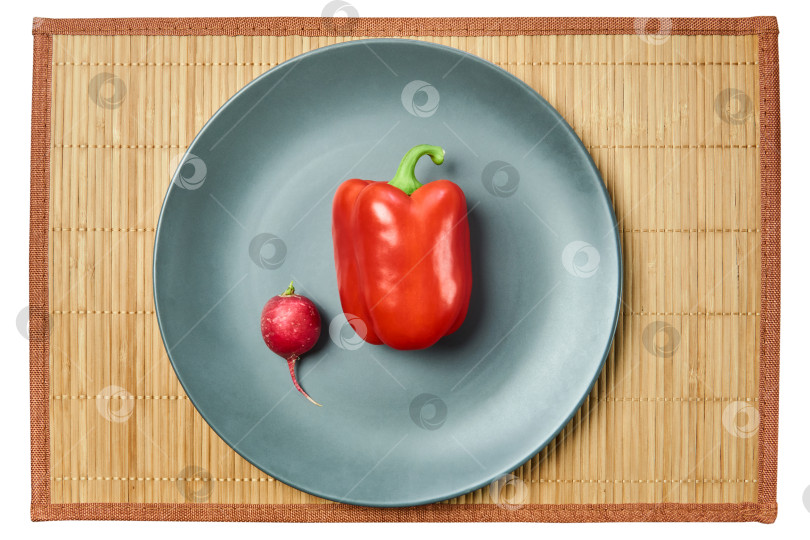 Скачать маленькая розовая редька и большой красный болгарский перец на серой тарелке с фотосток Ozero