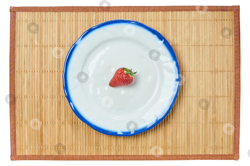 Скачать одинокая клубника на белой тарелке с синим ободком на тростниковой тарелке фотосток Ozero