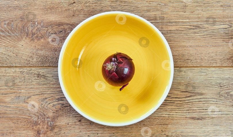 Скачать фиолетовая луковица красного сладкого лука на желтой тарелке на деревянной подставке фотосток Ozero