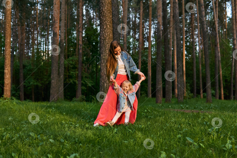 Скачать женщина с маленькой дочерью танцуют на лужайке в парке фотосток Ozero