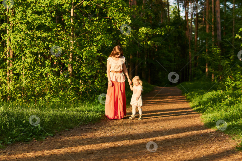 Скачать мать и маленькая дочь прогуливаются по дорожке в парке фотосток Ozero