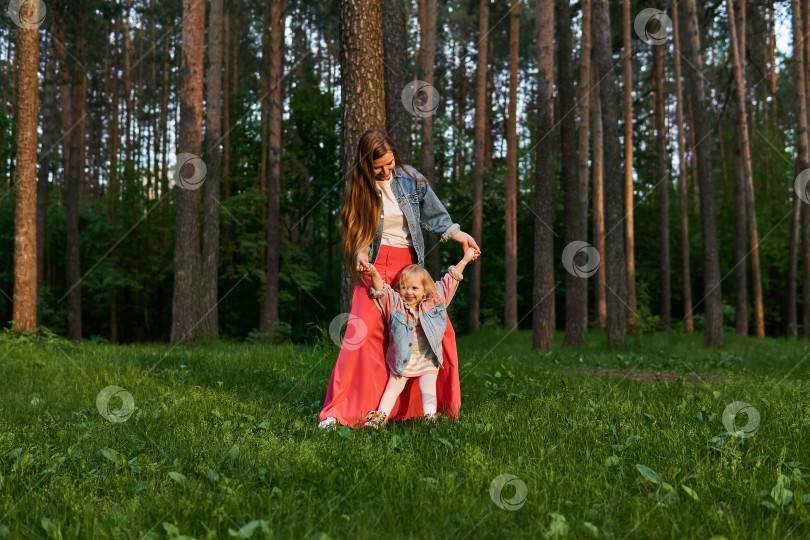 Скачать женщина с маленькой дочерью танцуют на лужайке в парке фотосток Ozero